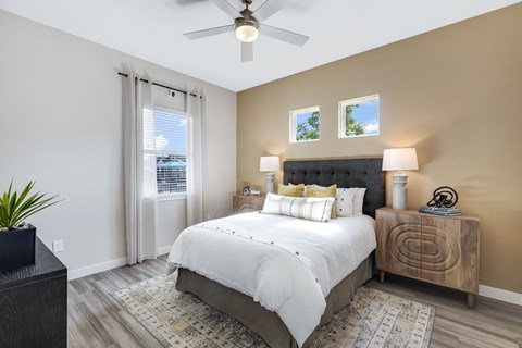 A bedroom with a large bed and a ceiling fan.